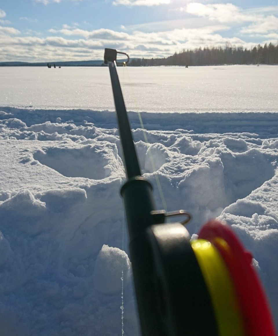 Ice fishing on the lake in Winter